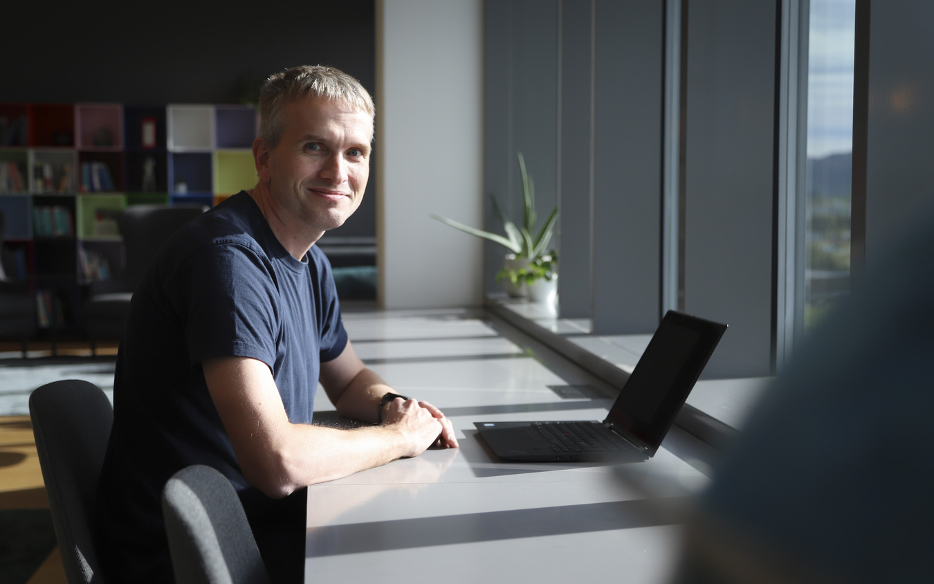 Man in office smiling at camera.