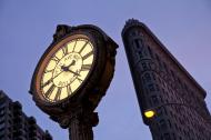 Fifth Avenue Clock with the Flatiron Building at the background in New York City.