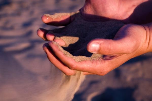 sand running thru hands - symbolizes time running thru your hands