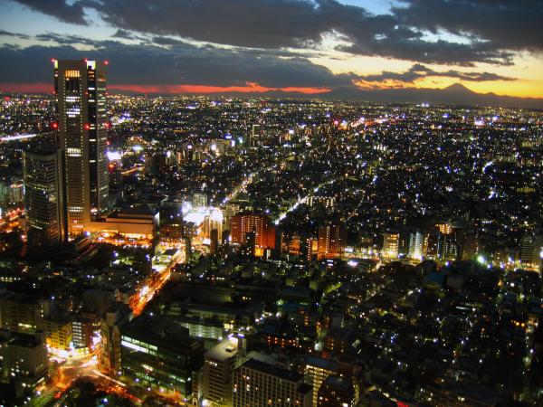 Twilight view over Tokyo metropolis with Mount Fuji on the horizon, back lighten by sun.