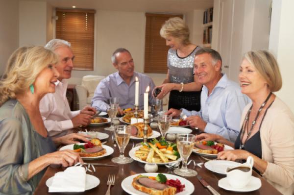 Friends Sitting Down At A Dinner Party Chatting Friends Sitting Down At A Dinner Party Chatting