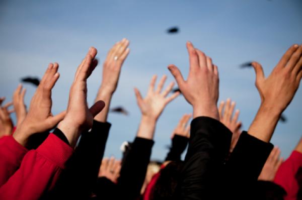 Group of people with arms raised above heads.