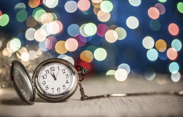 Stop Watch clock at midnight with multi colored lights or fireworks in the background Stop Watch clock at midnight multi colored lights in the background