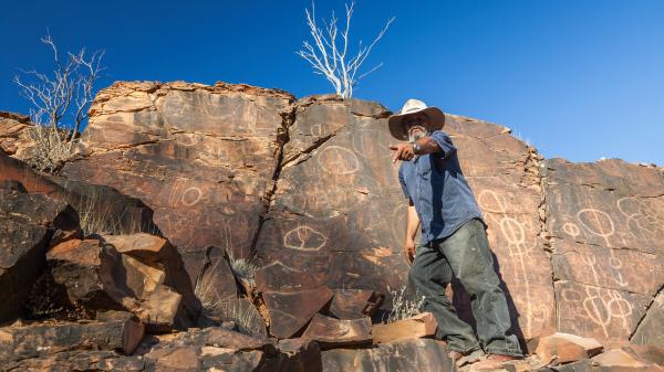 Aboriginal man at Chambers Gorge aboriginal engraving site in Flinders Ranges, South Australia.