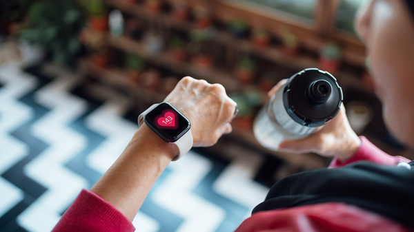 A fitness watch showing pulse rate on a woman´s wrist.