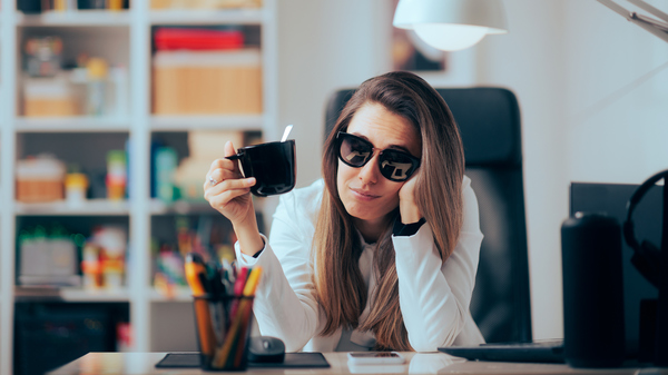 Hangover Woman Drinking Coffee Wearing Sunglasses in the Office stock photo