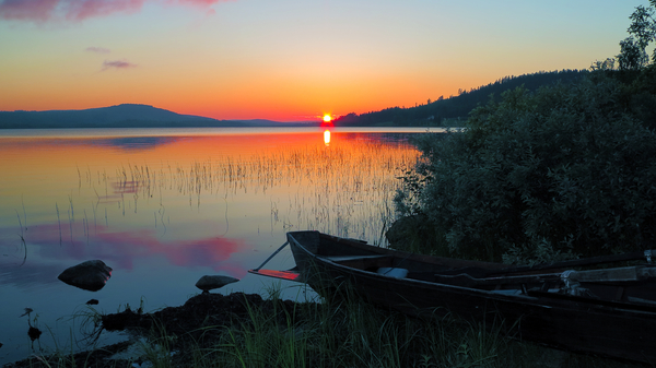 Image of the midnight Sun above a lake in the province of Norrbotten, Sweden.