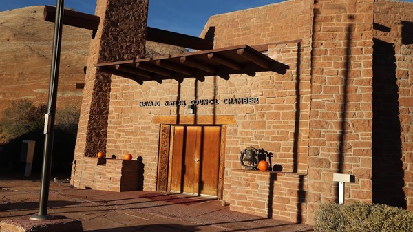 Stone house with "Navajo Nation Council Chamber" written above a large entrance door.