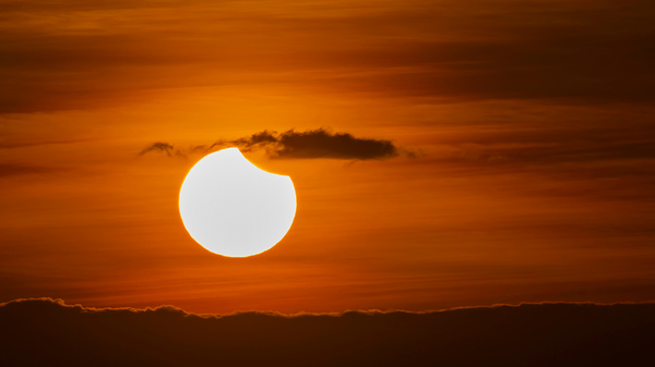 A partial solar eclipse, shortly after sunrise.