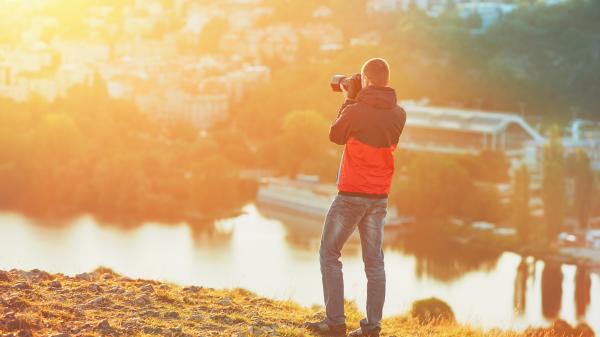 A photographer taking pictures at sunset.