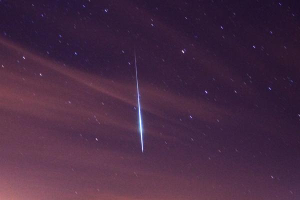 A meteorite, also known as a shooting star, in the night sky.