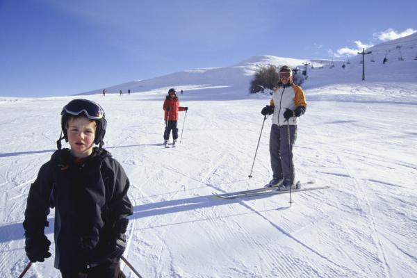 Ung gutt renner slalom sammen med mor og søster i skibakken. Gutt renner slalom med mor og søster i skibakken.