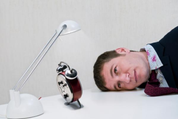 A slow day at work/business. a businessman has nothing else to do but watch the time pass by.