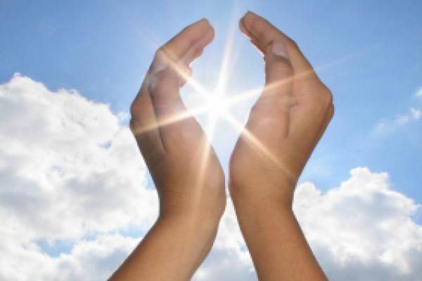 Woman’s hands surrounding the sun