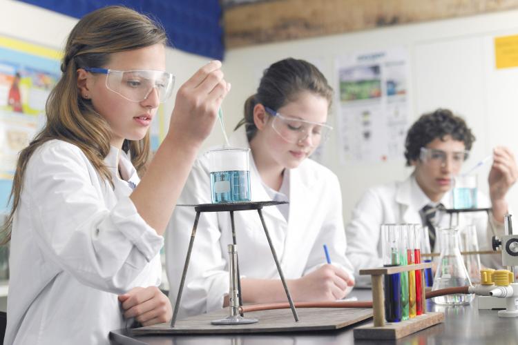 Students in a lab using a bunsen burner.