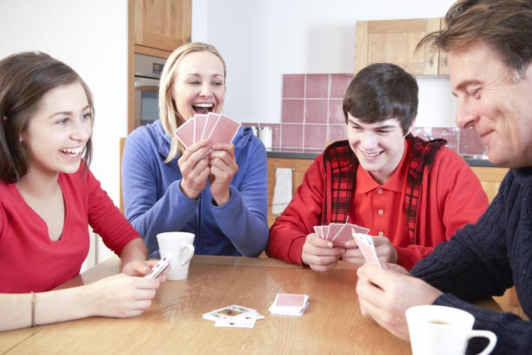 Family playing cards in kitchen.