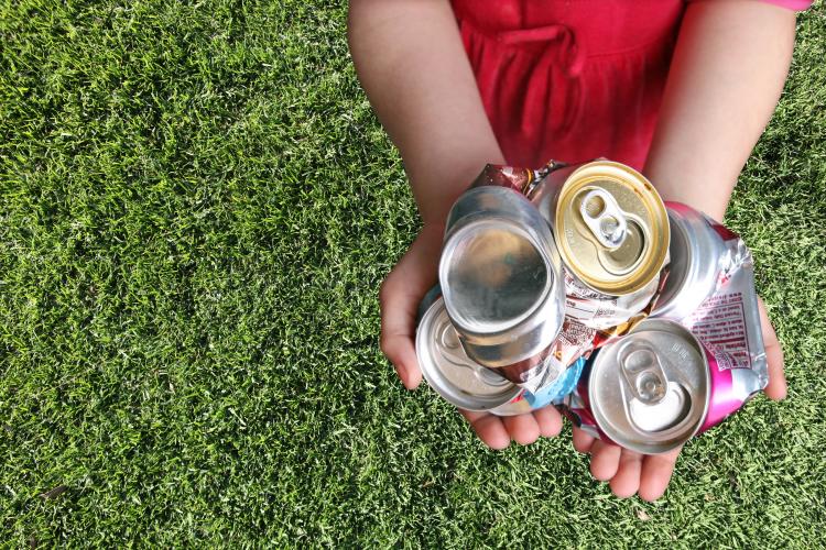 Aluminum cans crushed For recycling in a Child's hands.