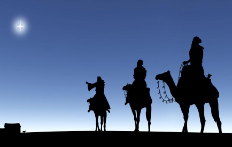 Three silhouetted camel riders representing the three magi of the Bible.