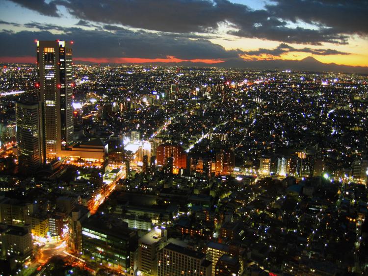 Twilight view over Tokyo metropolis with Mount Fuji on the horizon, back lighten by sun.