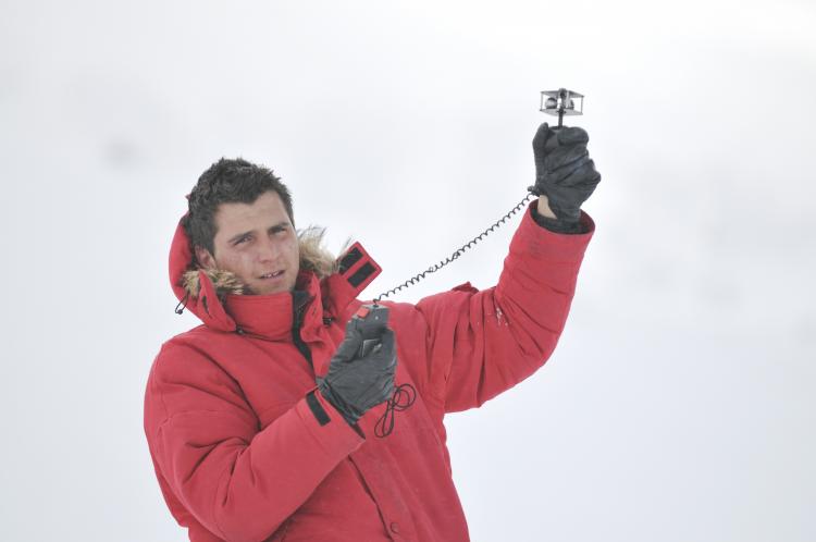 Young weather man measuring wind speed in the winter.