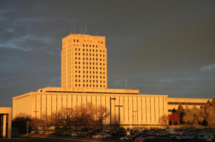 North Dakota capital tower with Department of Transportation building in foreground in early morning light.