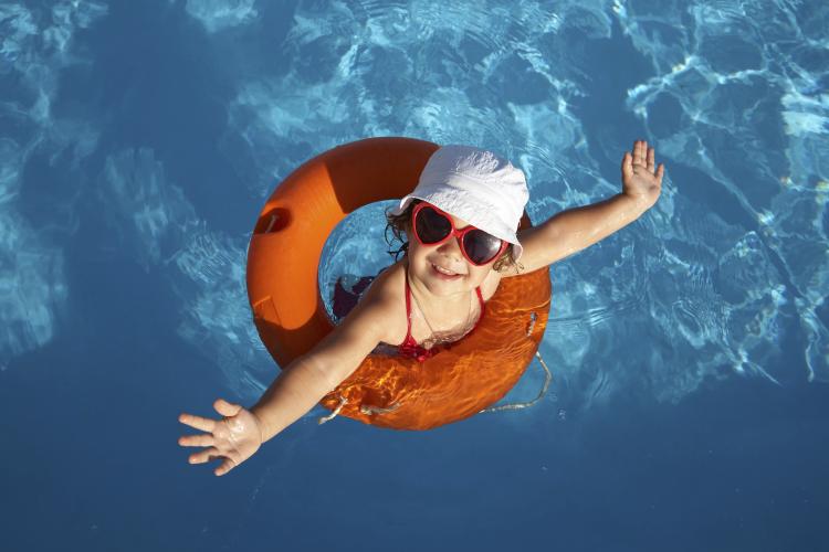 Overhead shot of a young girl in an orange life preserver.