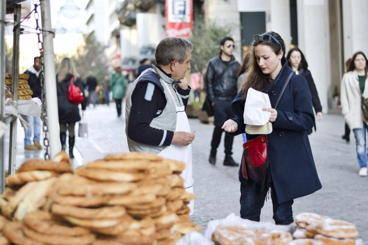 A woman buying from a street vendor in Ermou Street, downtown Athens.
