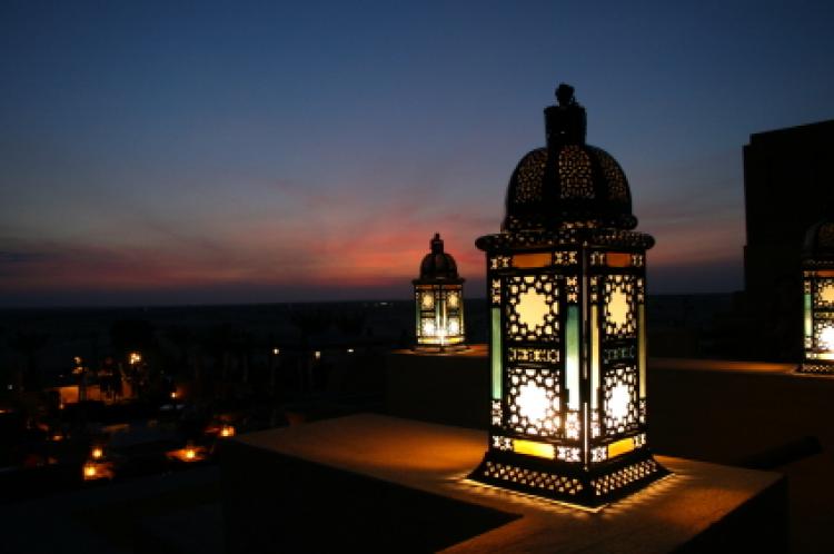 En tent ramadan-lanterne med solnedgang i bakgrunnen.