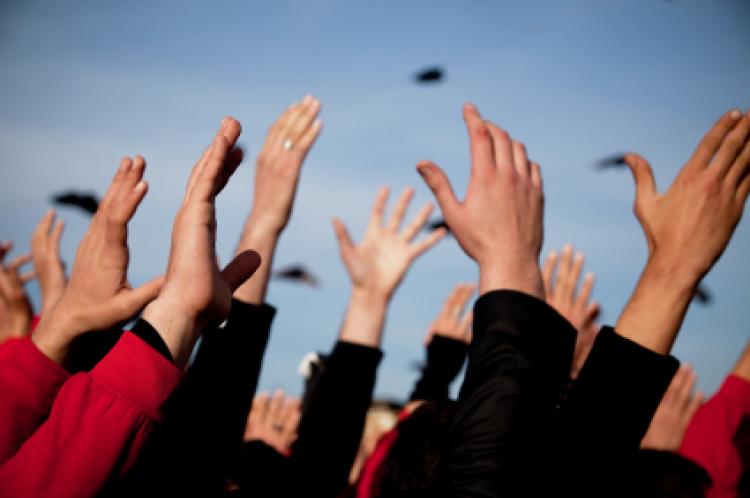 Group of people with arms raised above heads.