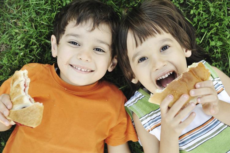 Young kids eating a sandwich.