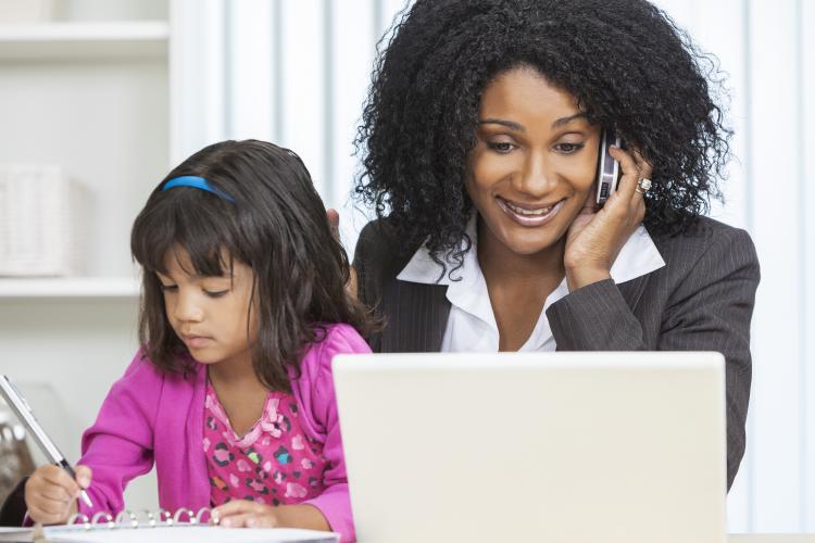African-American businesswoman at work with a child.