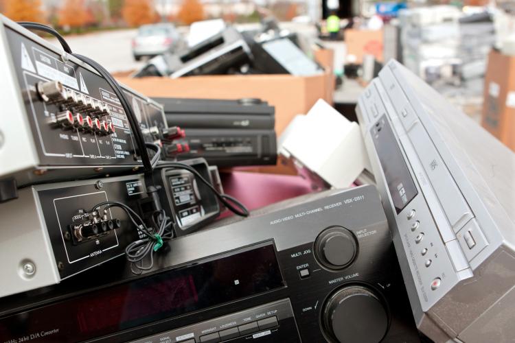 Old stereos and electronics pile up at a recycling event.