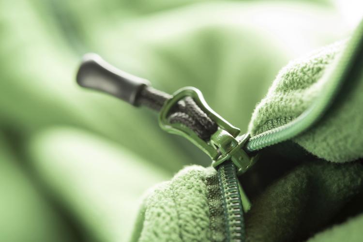 Close-up of a zipper on green fleece.