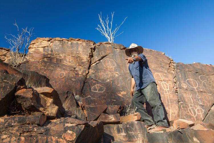 Aboriginal man at Chambers Gorge aboriginal engraving site in Flinders Ranges, South Australia.