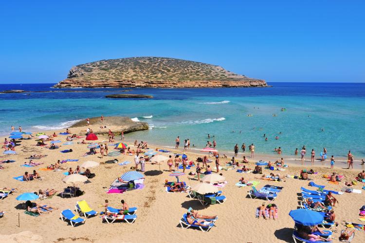 Sunbathers at Cala Conta beach in San Antonio, Ibiza, Spain.