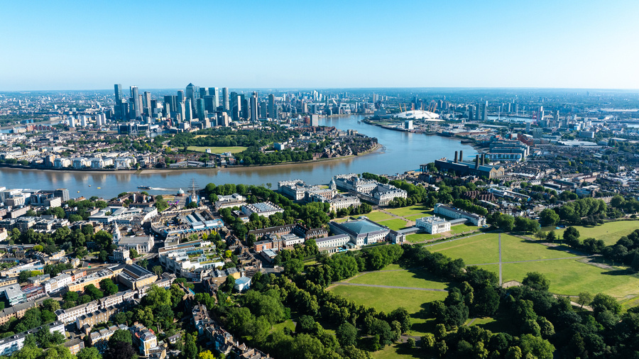 Aerial view of Greenwich Park and River Thames, with Canary Wharf skyline in the distance.