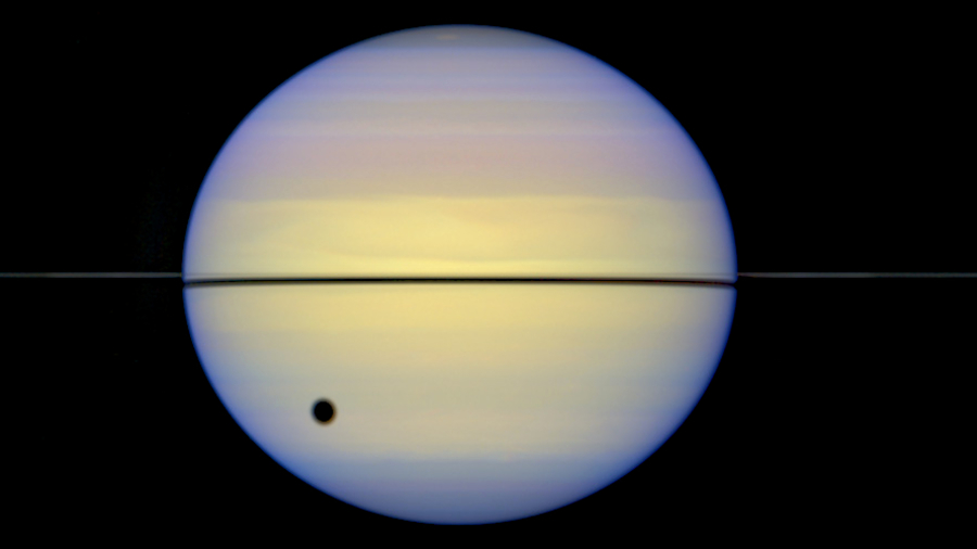 Saturn's rings seen edge-on by the Hubble Space Telescope. The large spot is the shadow of Saturn's moon Titan.