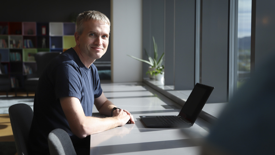 Man in office smiling at camera.