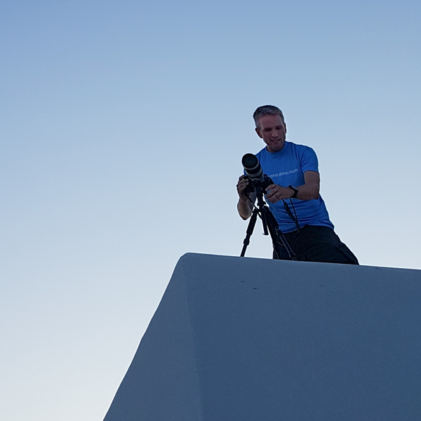 Picture of man on a roof with a camera.