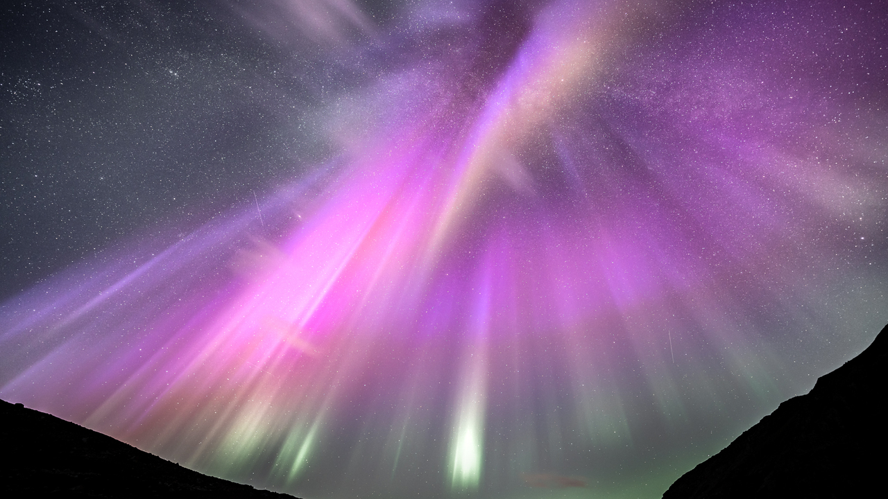 A view of vibrant purple northern lights over Harstad, northern Norway.