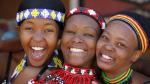 Three young Zulu women friends, dressed in traditional beaded Zulu garments.