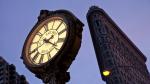Fifth Avenue Clock with the Flatiron Building at the background in New York City.