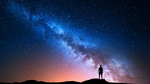 Silhuette eines Mannes, der den Sternenhimmel mit Milchstraße betrachtet.