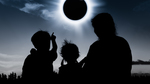 Silhouettes of two children and a woman watching the diamond ring effect on a totally eclipsed Sun.