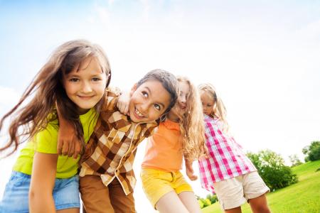 Group of little 6 and 7 years old smiling kids outside in the park.