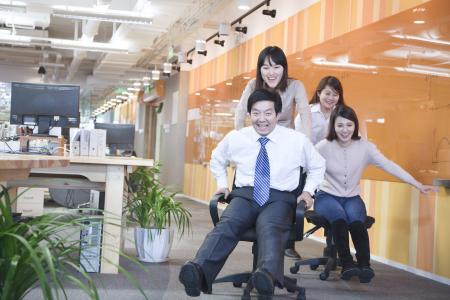 Colleagues having a chair race.