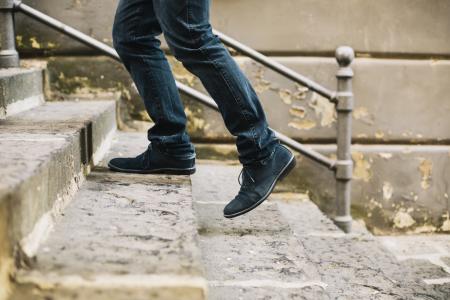 Close-up of a man's feet walking upstairs.