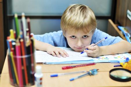 Left-handed boy doing homework.