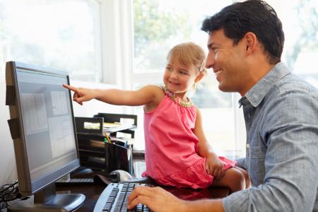 Father working in office with daughter.