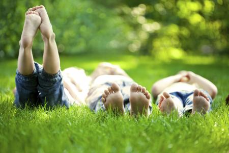 Three children relaxing in the grass.